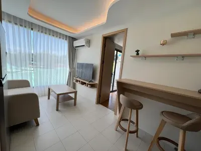 a living room with a bed and a table and chairs at Fantasea Condominium Kamala in Kamala Beach