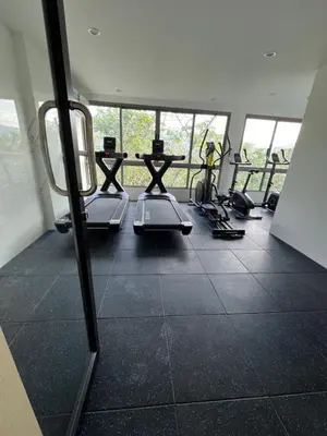 a gym with several treadmills and a room with windows at Fantasea Condominium Kamala in Kamala Beach