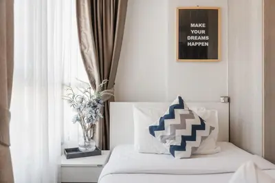 a bedroom with a bed with a vase of flowers on it at C185 Centrio 2BR Condo Walk to Mall Near Town in Phuket Town