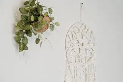 a white ornament hanging on a wall with a plant at C185 Centrio 2BR Condo Walk to Mall Near Town in Phuket Town