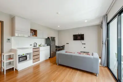 a kitchen and living room with a couch in a room at C188 Modern Condo Pool Gym & Walk to Rawai Beach in Rawai Beach
