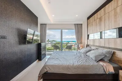 a bedroom with a large bed and a large window at C189 Beachside Luxury in Rawai Sea View and Gym in Rawai Beach