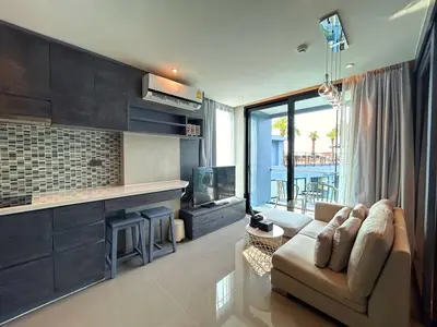 a living room with a couch and a television at C191 CityGate Kamala Stylish Stay by Pools and Gym in Kamala Beach