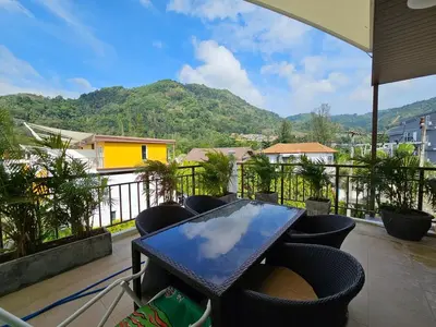 a table and chairs on a balcony with a view at 3-Bedroom Town House in Kamala in Kamala Beach