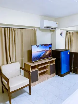 a living room with a tv and a chair at ANK Residence Patong in Patong Beach