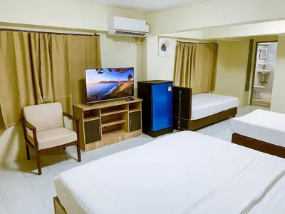 a hotel room with two beds and a flat screen tv at ANK Residence Patong in Patong Beach