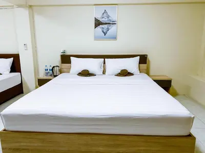 a bedroom with a large white bed with two hats on it at ANK Residence Patong in Patong Beach