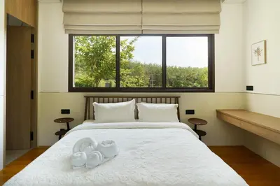 a bedroom with a bed with two white shoes on it at Modern 3 Bdr Villa Tree O'Clock Bangtao With a Pool in Ban Pak Lak