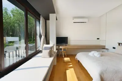 a bedroom with two beds and a tv and a balcony at Modern 3 Bdr Villa Tree O'Clock Bangtao With a Pool in Ban Pak Lak