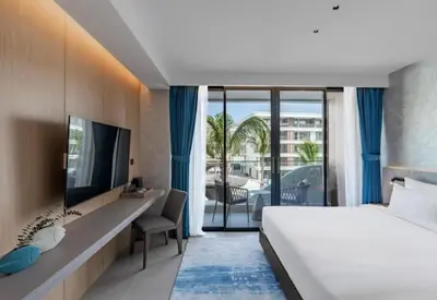 a hotel room with a bed and a balcony at Sunshine Beach Residence Resort in Phuket Town