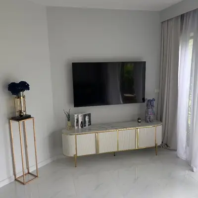a living room with a tv on a white wall at Allamanda 3 Laguna Phuket by Star in Laguna Phuket