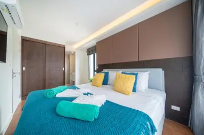 a bedroom with a large bed with towels on it at 1 Bedroom Apartment - The Aristo Resort by HCR in Surin Beach