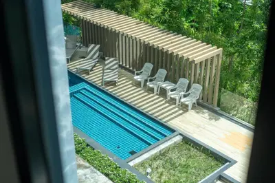 an overhead view of a swimming pool with chairs and a deck at 1 Bedroom Apartment - The Aristo Resort by HCR in Surin Beach