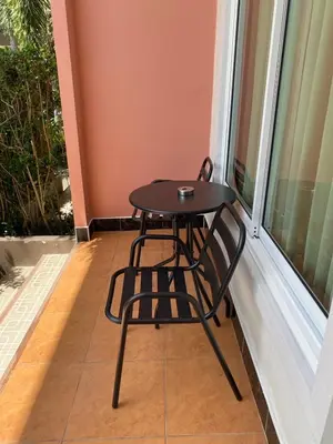 a small black table and chair on a balcony at วันสมายล์ รีสอร์ท in Ban Klang