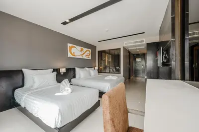 two beds in a hotel room with white sheets at C197 Condo 1BR with Pool 3 Min Walk to Beach in Patong Beach