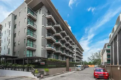an apartment building with a red car parked in a parking lot at C197 Condo 1BR with Pool 3 Min Walk to Beach in Patong Beach