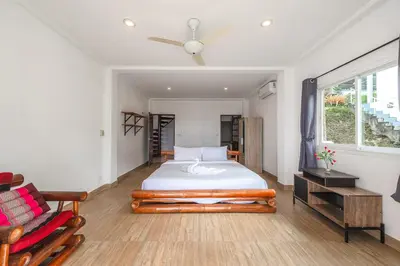 a bedroom with a bed and a chair and a window at V199 Villa 4BR Relaxing with Best Views in Patong in Patong Beach