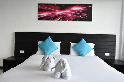 a bed with a pair of shoes sitting on it at Lae Lay Suite in Karon Beach