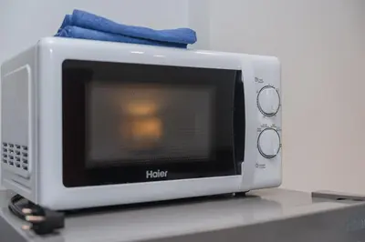 a microwave oven with a towel on top of it at C199 Condo 1BR Walk to Lake, Beach, Bars & Market in Rawai Beach