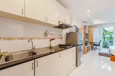 a kitchen with white cabinets and a stainless steel sink at C199 Condo 1BR Walk to Lake, Beach, Bars & Market in Rawai Beach