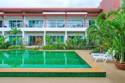 a hotel with a swimming pool in front of a building at C200 Relaxing 1BR Stay Walk to Nai Harn Beach in Rawai Beach