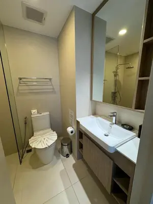 a bathroom with a toilet and a sink and a mirror at Cozy studio Laguna SkyPark Phuket in Laguna Phuket