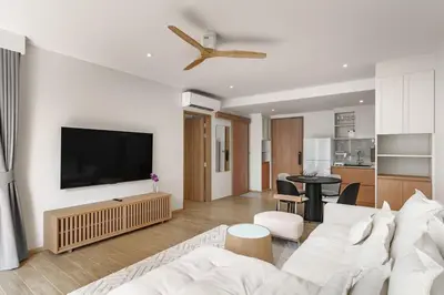 a living room with a white couch and a flat screen tv at Laguna Beachside by ShowProperty in Bang Tao Beach