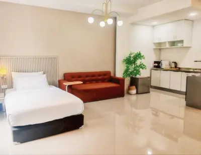 a bedroom with a bed and a couch in it at The Sleepy Place in Patong Beach