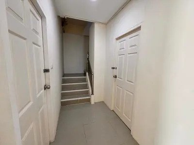 a hallway with a white door and stairs at Tropikathu Guest House in Kathu