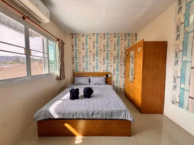 a bedroom with a bed with two dogs laying on it at Tropikathu Guest House in Kathu