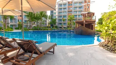 a swimming pool with two chairs and an umbrella at G16 Title Naiyang 36м2Ватсап669З5В2I976 in Nai Yang Beach