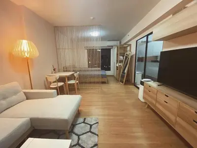 a living room with a couch and a television and a table at Vista Old Town Phuket in Phuket Town