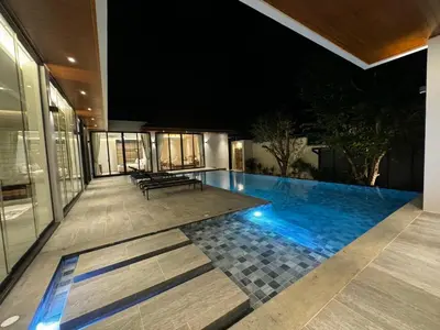 a house with a swimming pool at night at The Nature Villa Phuket in Rawai Beach