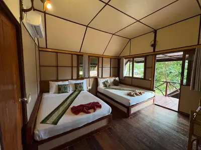 a bedroom with two beds in a room with windows at Phi Phi Ingphu Viewpoint Hotel in Phi Phi Don