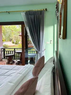 a bed sitting in a room with a window at Sun-San Thalane Resort in Ban Laem