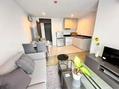 a living room with a couch and a kitchen at Centrio 2 bed rooms in Phuket Town