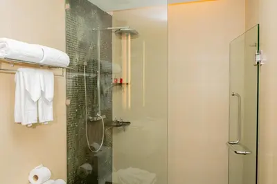 a bathroom with a shower with a glass door at Beachfront 1 BR Hotel Infinity Pool Patong Phuket in Patong Beach