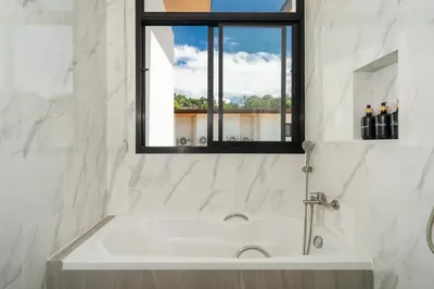 a bath tub in a bathroom with a window at Kamala Sunshine Villa - Goldena Twin in Kamala Beach