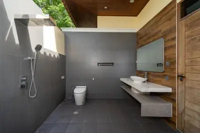 a bathroom with a toilet and a sink and a mirror at Ocean Palms Private Pool Villas in Ban Thalat Choeng Thale