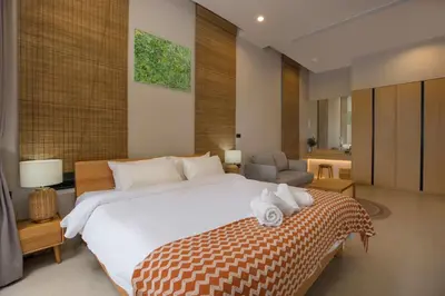 a bedroom with a large bed and a living room at Chalong Bay View 3BR Pool Villa Long One B10 in Chalong