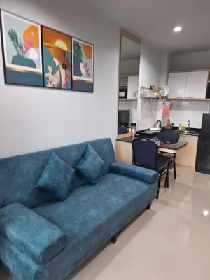 a living room with a blue couch and a kitchen at The Sea Condo Ao Nang Apartment Relax with Sea View in Ban Khlong Haeng