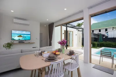 a living room with a table and a couch at Your Tropical Island Home - New & Modern 2BR Pool Villa Seamate in Chalong