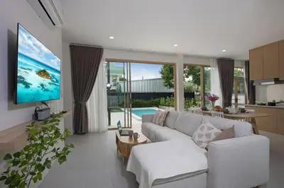 a living room with a white couch and a tv at Your Tropical Island Home - New & Modern 2BR Pool Villa Seamate in Chalong