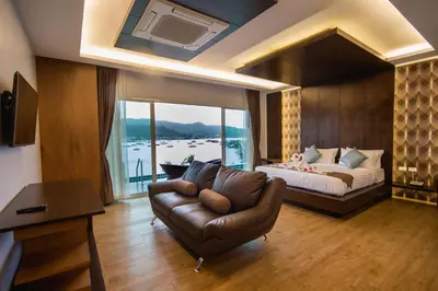 a bedroom with a couch and a bed with a window at Phi Phi Cliff Beach Resort in Phi Phi Don