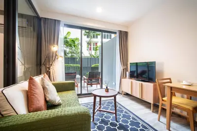 a living room with a green couch and a table at \u7cbe\u9009\u623f\u6e906\u53f7\u82ad\u4e1c\u6d77\u6ee9\u7cbe\u88c5\u516c\u5bd35\u5206\u949f\u5230\u6d77\u6ee910\u5206\u949f\u5230\u6d77\u6ee9Bangla\u9152\u5427\u8857Jungceylon\u5546\u573a in Patong Beach