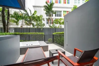 a balcony with a table and chairs and a tub at \u7cbe\u9009\u623f\u6e906\u53f7\u82ad\u4e1c\u6d77\u6ee9\u7cbe\u88c5\u516c\u5bd35\u5206\u949f\u5230\u6d77\u6ee910\u5206\u949f\u5230\u6d77\u6ee9Bangla\u9152\u5427\u8857Jungceylon\u5546\u573a in Patong Beach