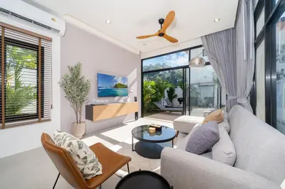 a living room with a couch and a tv at Villa Chandlers - Goldena Twin in Kamala Beach