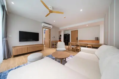 a living room with a white couch and a table at Apartment at Laguna Beachside by Lofty in Bang Tao Beach