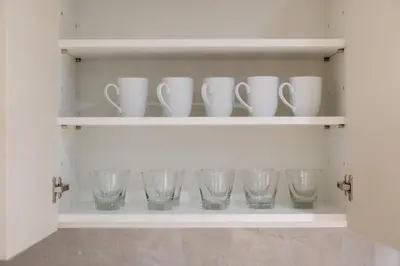 a shelf with cups and glasses on it at Apartment at Laguna Beachside by Lofty in Bang Tao Beach