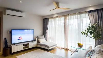 a living room with a flat screen tv and a couch at Beachside Residence 4 floor, Seaside, 250m to the beach in Bang Tao Beach